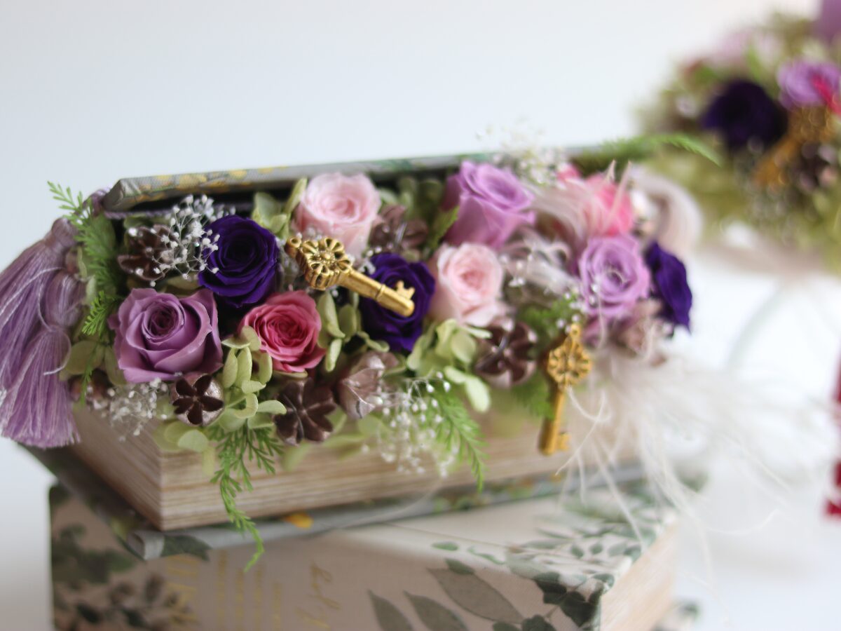 本から花があふれるデザインのお誕生日のアレンジ